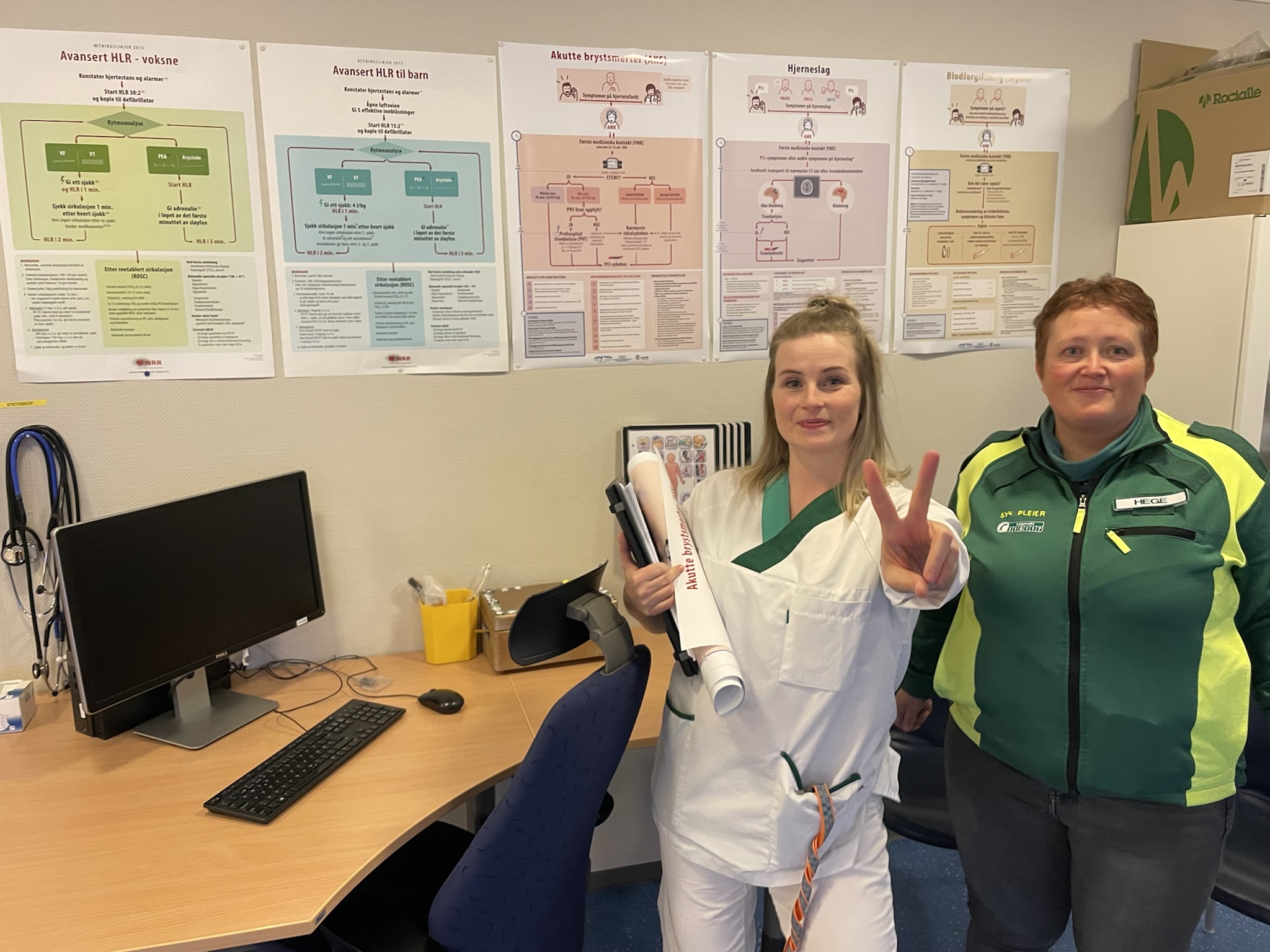 En mann og en kvinne i laboratoriefrakk som holder en bok