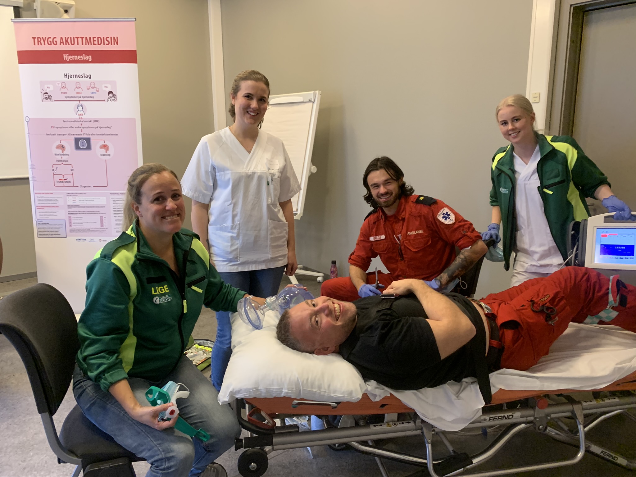 En gruppe mennesker rundt en person som ligger på en sykehusseng