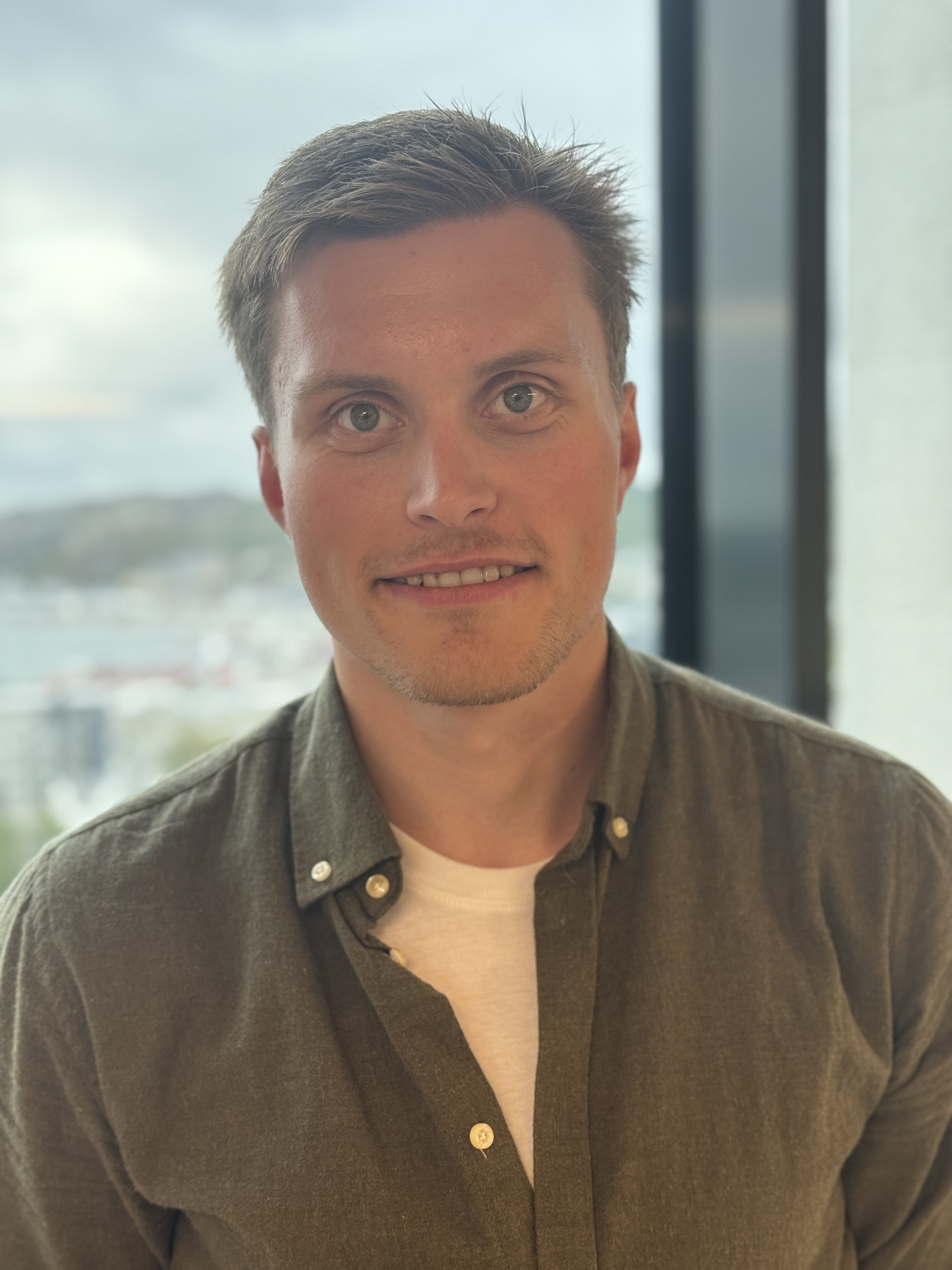 En mann som smiler til kameraet