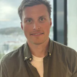 En mann som smiler til kameraet