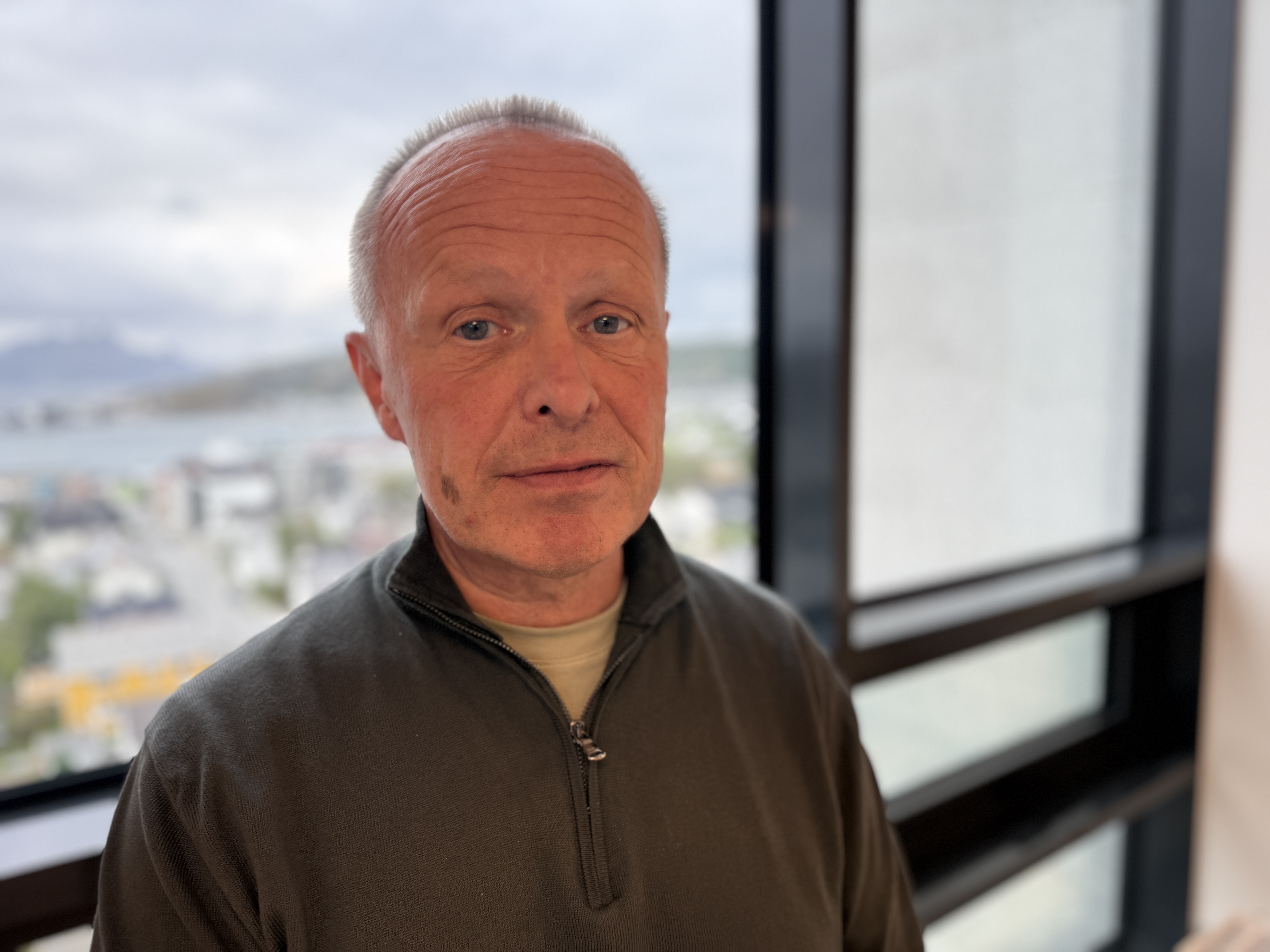 En mann som står foran et vindu