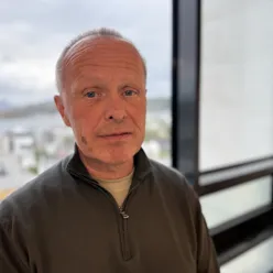 En mann som står foran et vindu