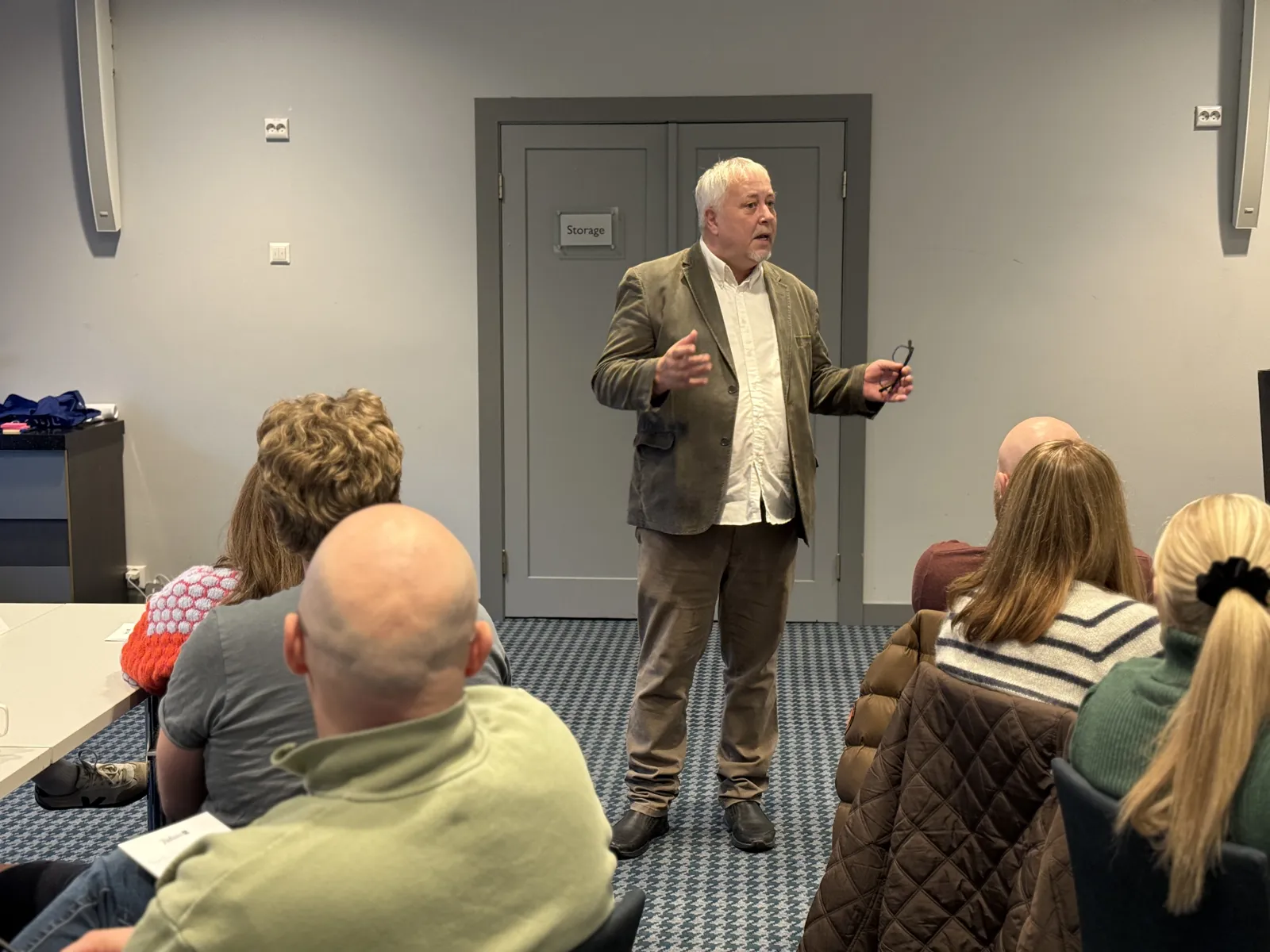 En person som står foran en gruppe mennesker