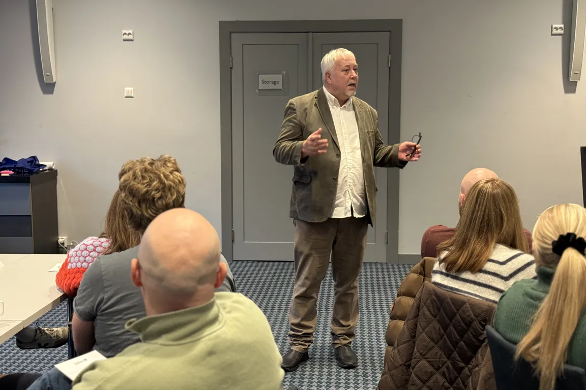 En person som står foran en gruppe mennesker